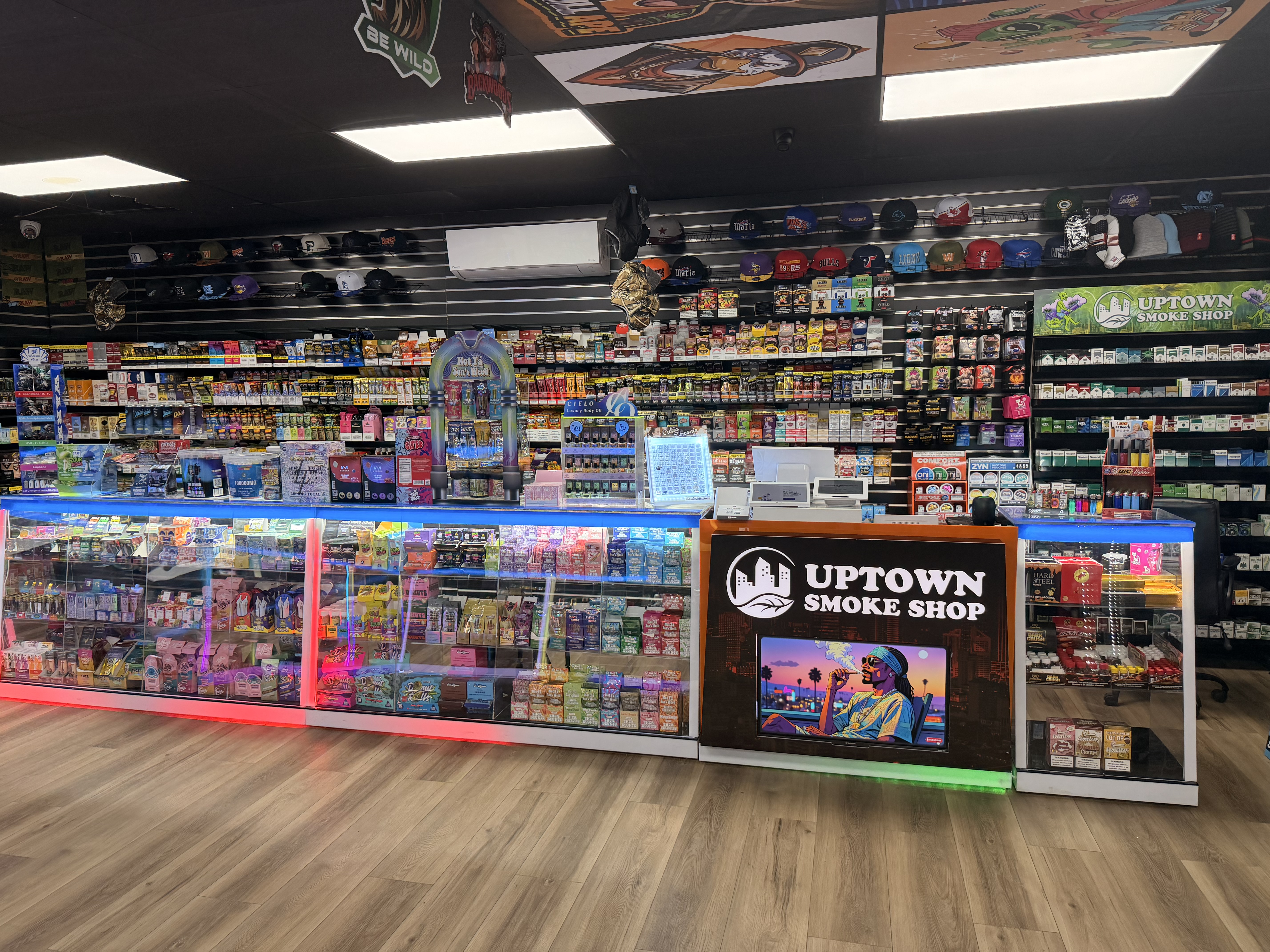 Uptown Smoke Shop front counter with LED display cases and product wall